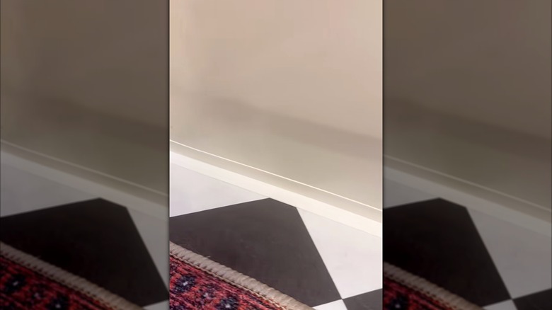 Woman applied peel-and-stick caulk at the base of her tub.