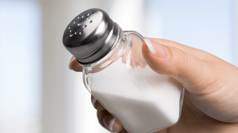 person holding salt shaker