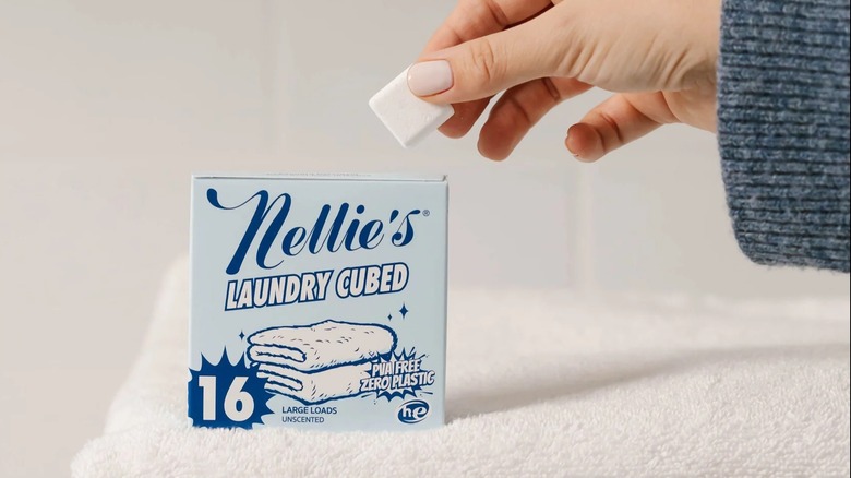 A hand holding a Nellie's Laundry Cubed laundry cube.