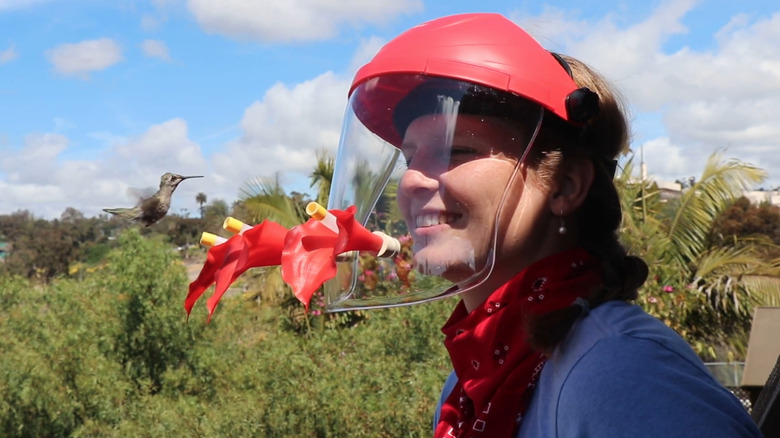 Woman wearing HummViewer near hummingbird