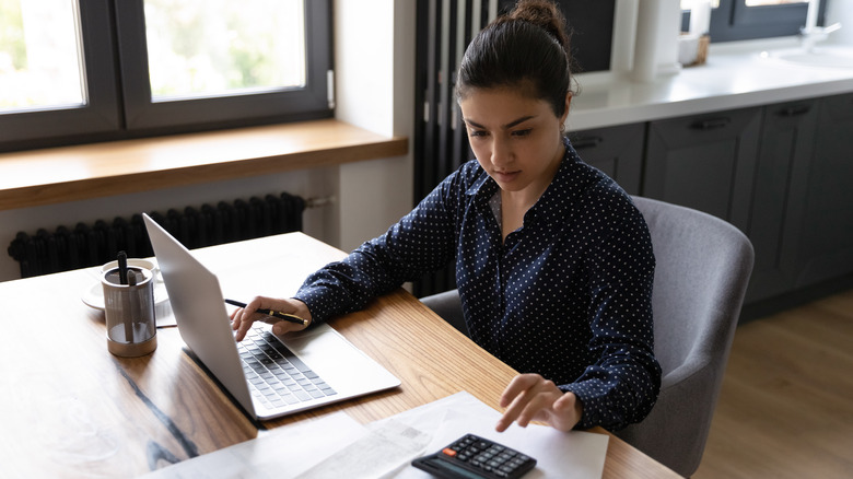 woman with calculator filing taxes