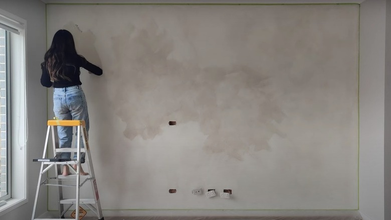 woman painting wall with limewash