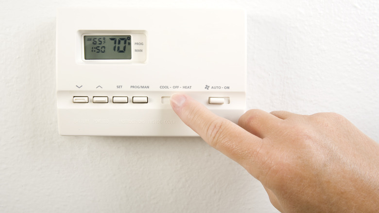 Person adjusting thermostat