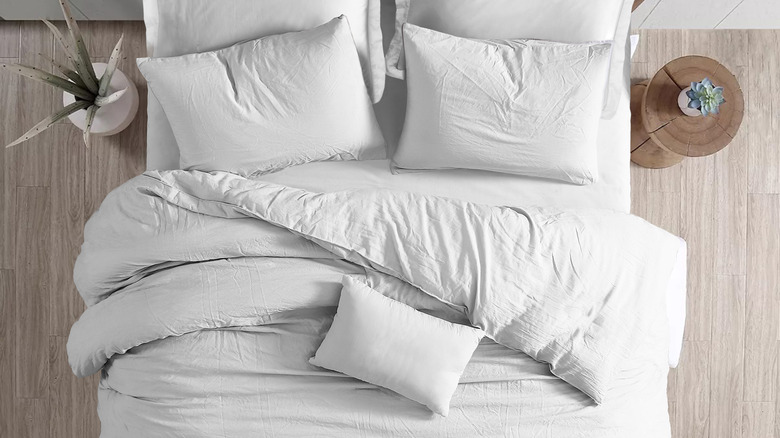 Made up bed with all white linens