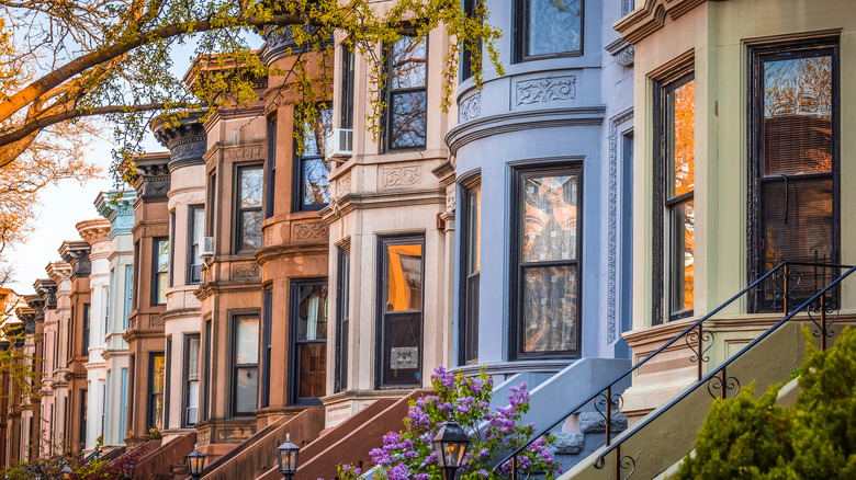 A row of colorful brownstones in Park Slope are shown at sunset