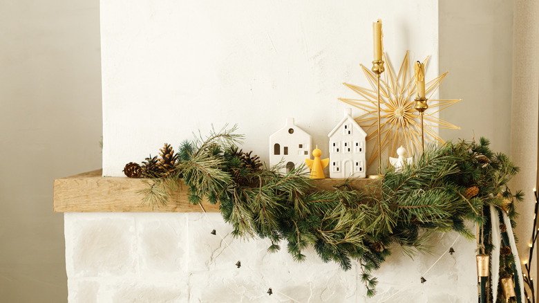 A styled mantel with candles and greenery