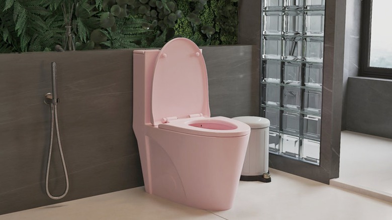 A modern bathroom with a pink toilet