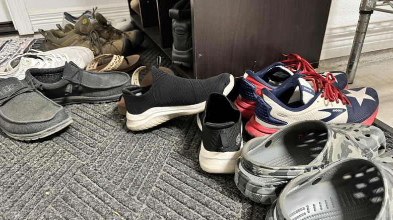 Pile of shoes on mat in entryway