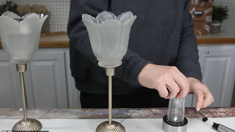 DIY solar lights made with candlestick stands, glass shades for the tops, and solar lights inside