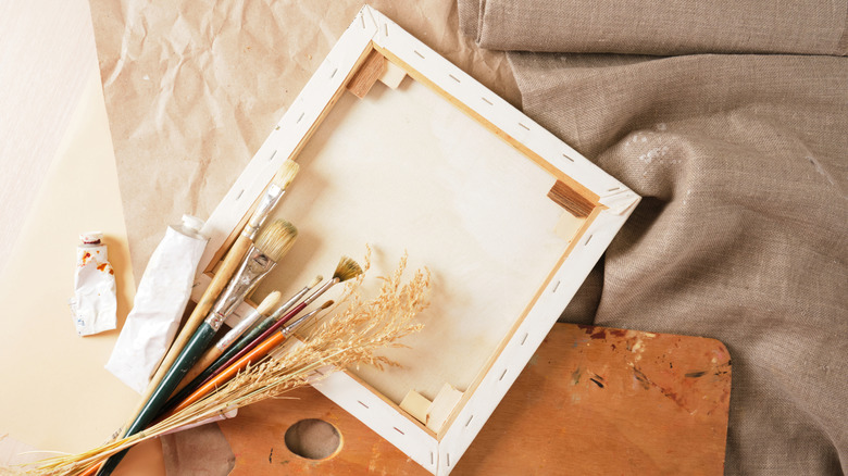 A canvass with brushes and paint on linen