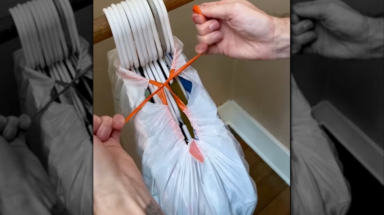 Packing clothes with hangers in a trash bag