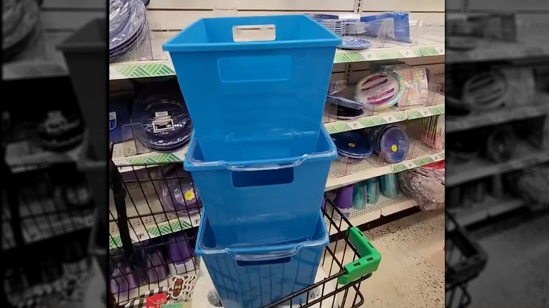 Blue plastic storage bins stacked in cart