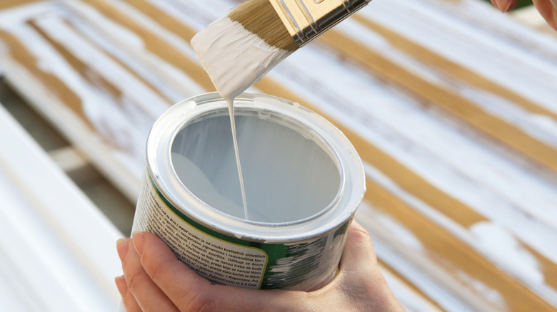 Someone with a paint brush and white paint