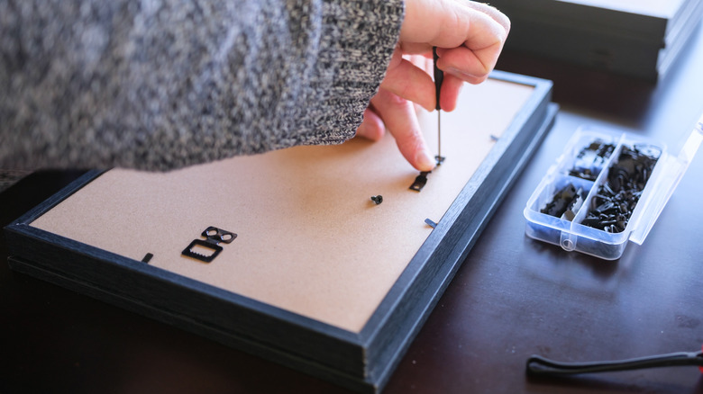 person working on picture frame