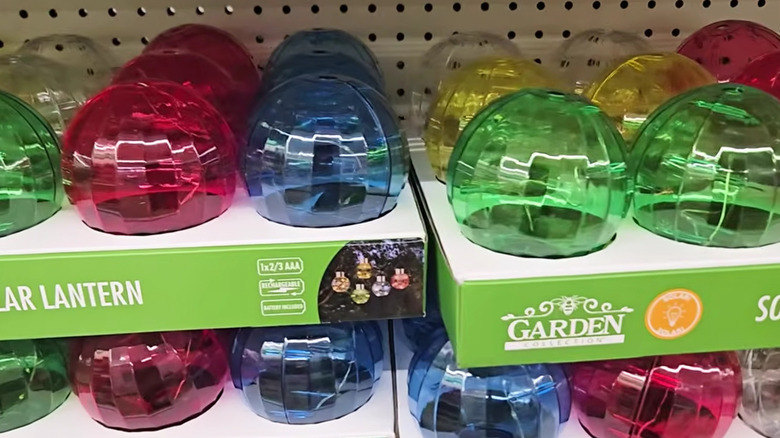 A closeup photo shows colorful solar lanterns on shelves at a Dollar Tree