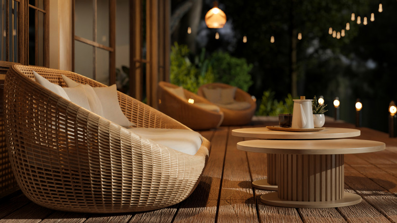 A table and chair sit on a dimly lit patio