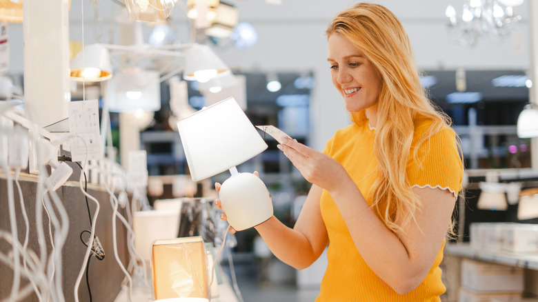 A person is shopping for lamps and looking at the price