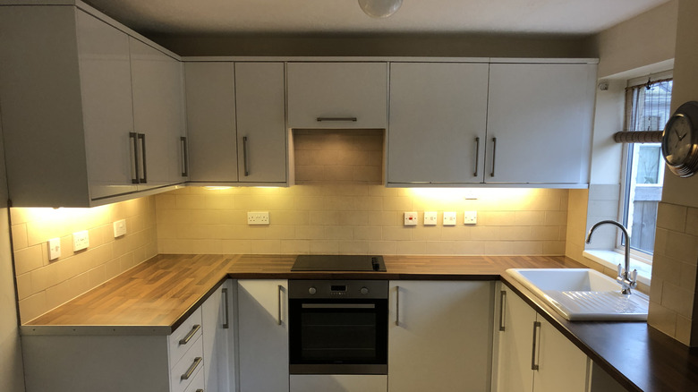 The kitchen space is illuminated by lights underneath the cabinets