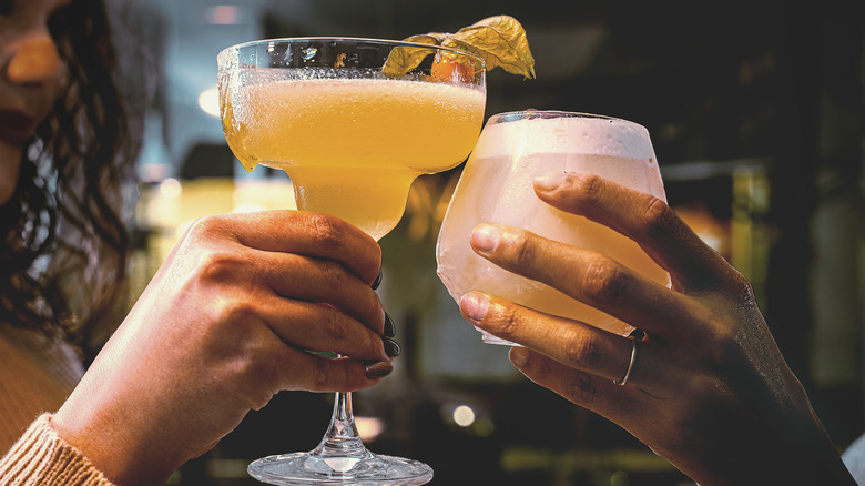 Female hands holding cocktail glasses in a toast