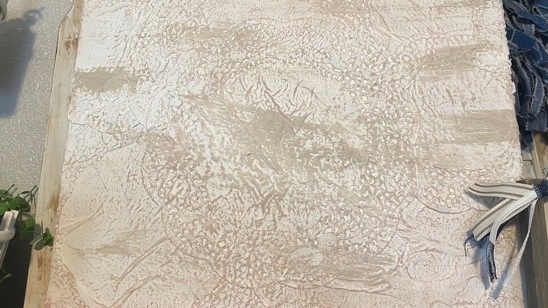 Close up of a textured canvas piece made with doilies