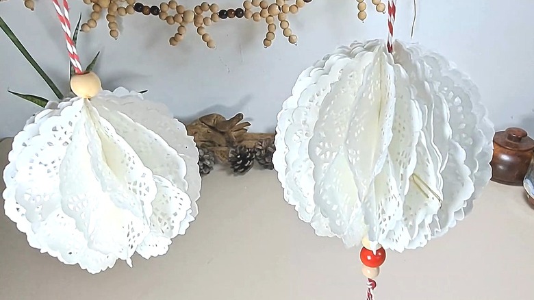 Two hanging orbs made from paper doilies hanging from string