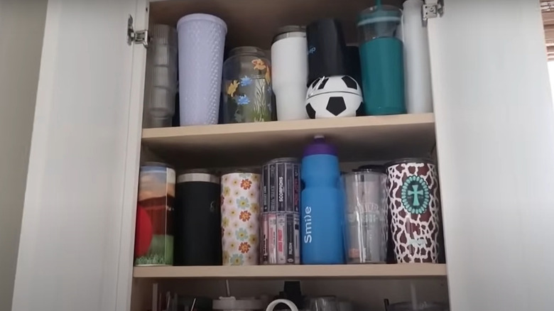 Reusable water bottles filling up a kitchen cabinet
