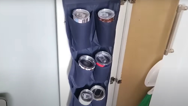 Water bottles in a shoe organizer hanging on a closet door