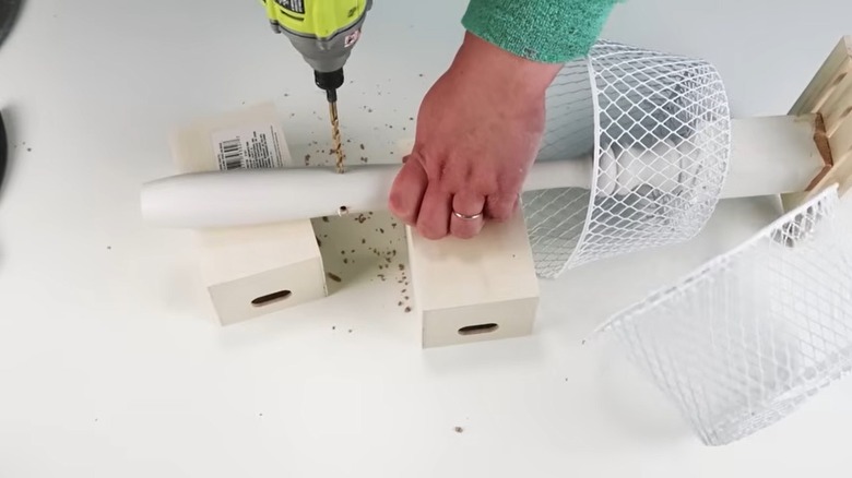 Person drilling hole into table leg to make DIY storage solution