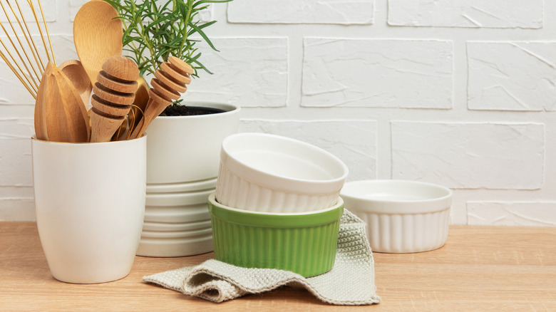 Ramekins and kitchen utensils against a brick wall