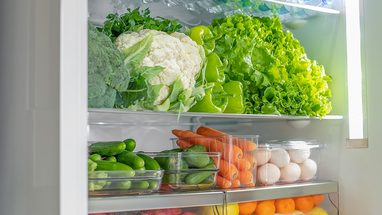 Containers in a fridge filled with vegetables