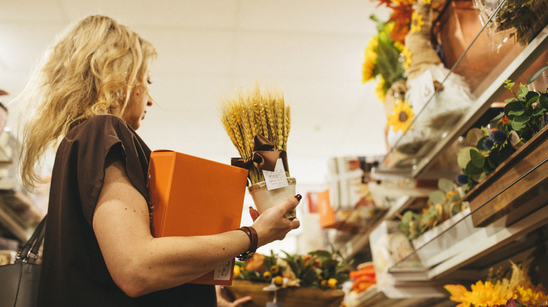 Woman shopping for fall decor in store aisle