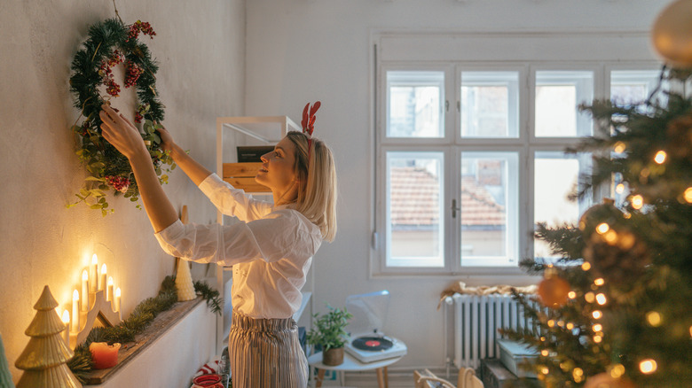 woman hanging a Christmas wreath