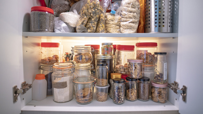 Kitchen cabinet with jars and bags of spices and other ingredients
