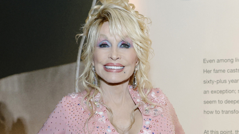 Dolly Parton smiling for the camera at a museum event.