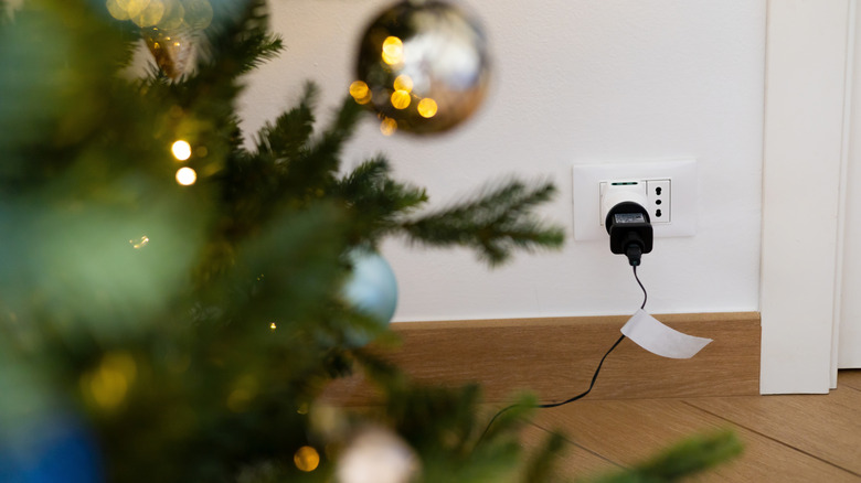 Christmas tree with lights plugged into the wall.