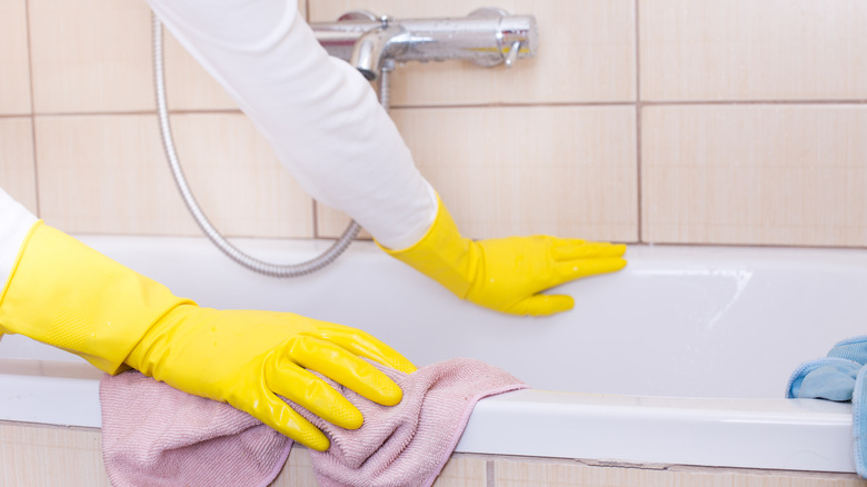 person cleaning bathtub