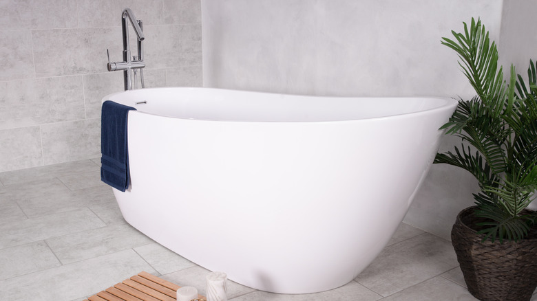 white bathtub with blue towel