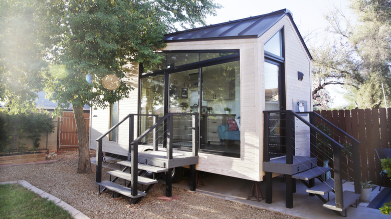 A cute tiny home sits in a backyard