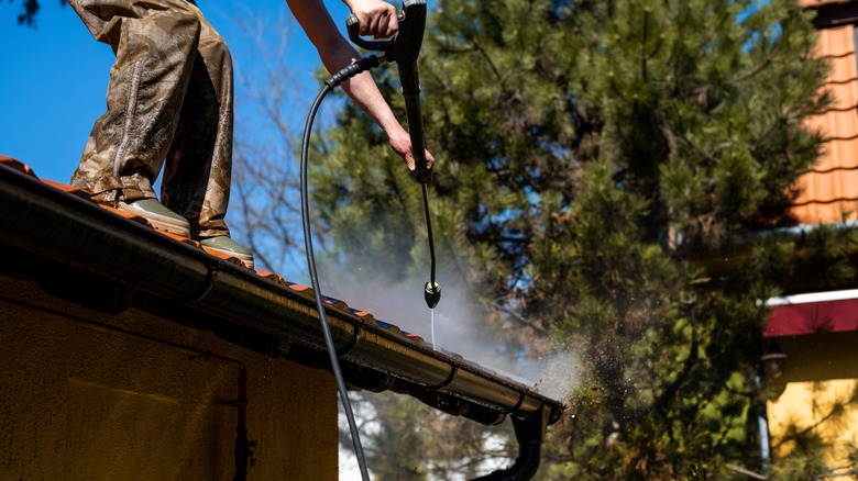 Man cleaning roof gutter