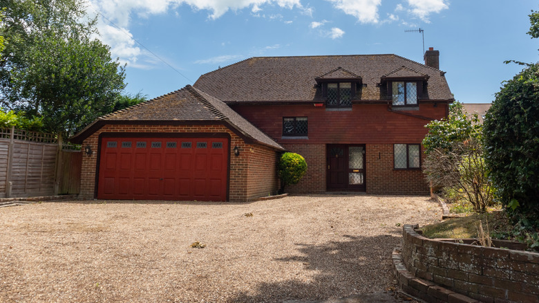 red brick home with gravel driveway
