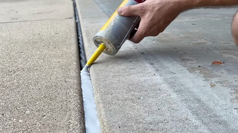 Person seals the filled expansion gap with self-leveling caulk.