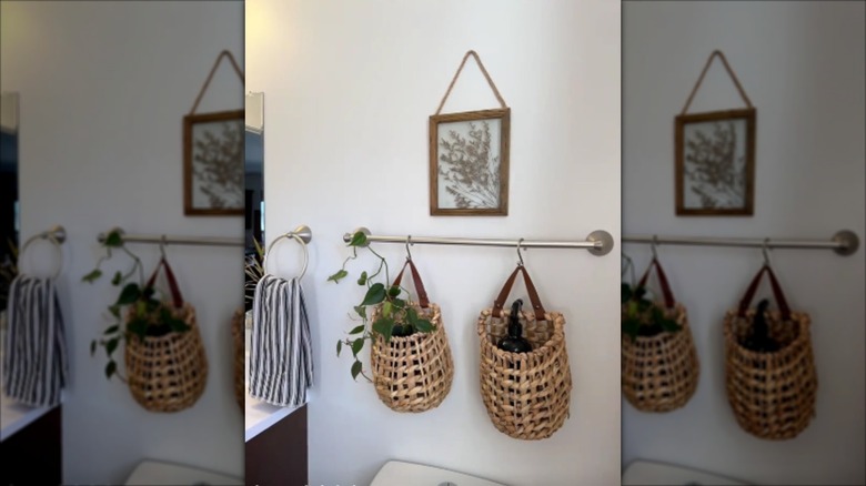 Two decorative baskets hanging on a towel bar