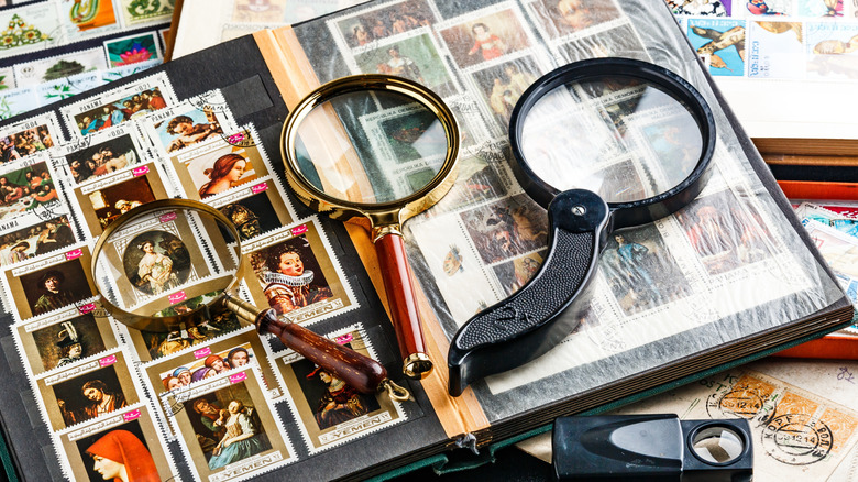 A stamp collection in a book with three magnifying glasses.