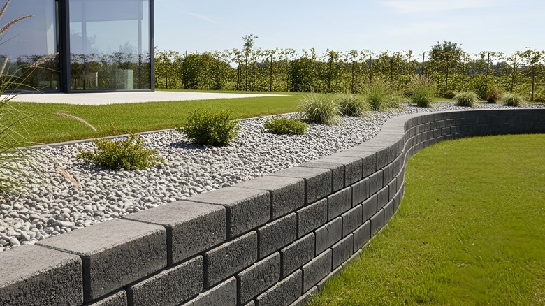 A landscaped yard with a retaining wall.