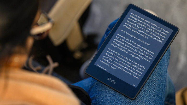 A person reading a Kindle placed on their lap