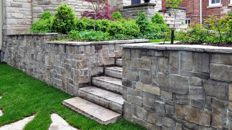 Manicured landscaping around stone front