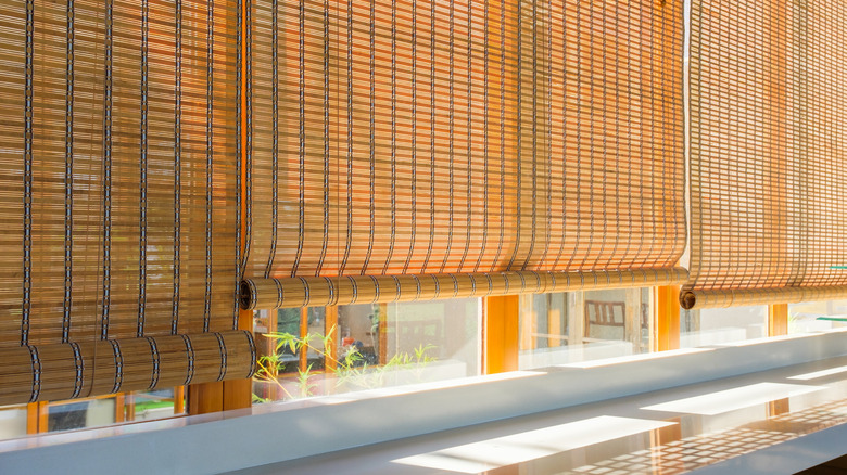 Large window with multiple bamboo window shades partially open