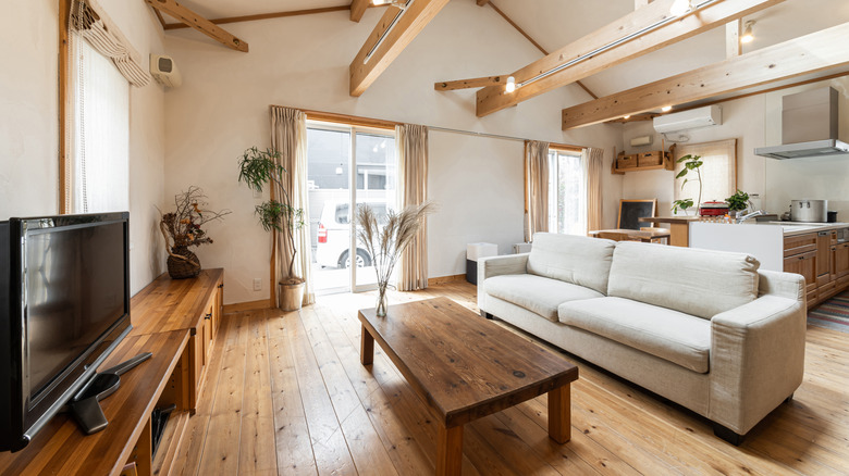 Light flooding in a room with wood furniture including a table, console, and coffee table
