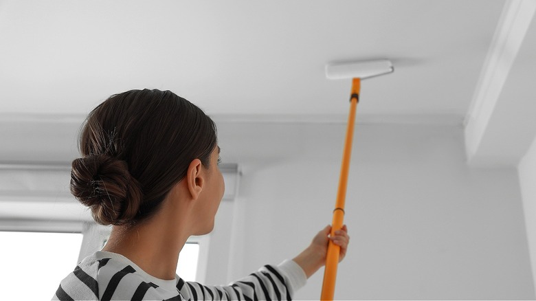 Person applying primer to ceiling