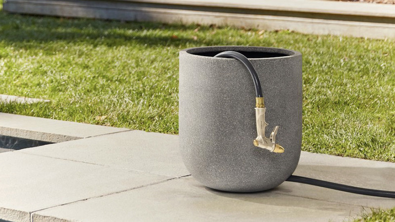 Hose stored in cylindrical container on patio